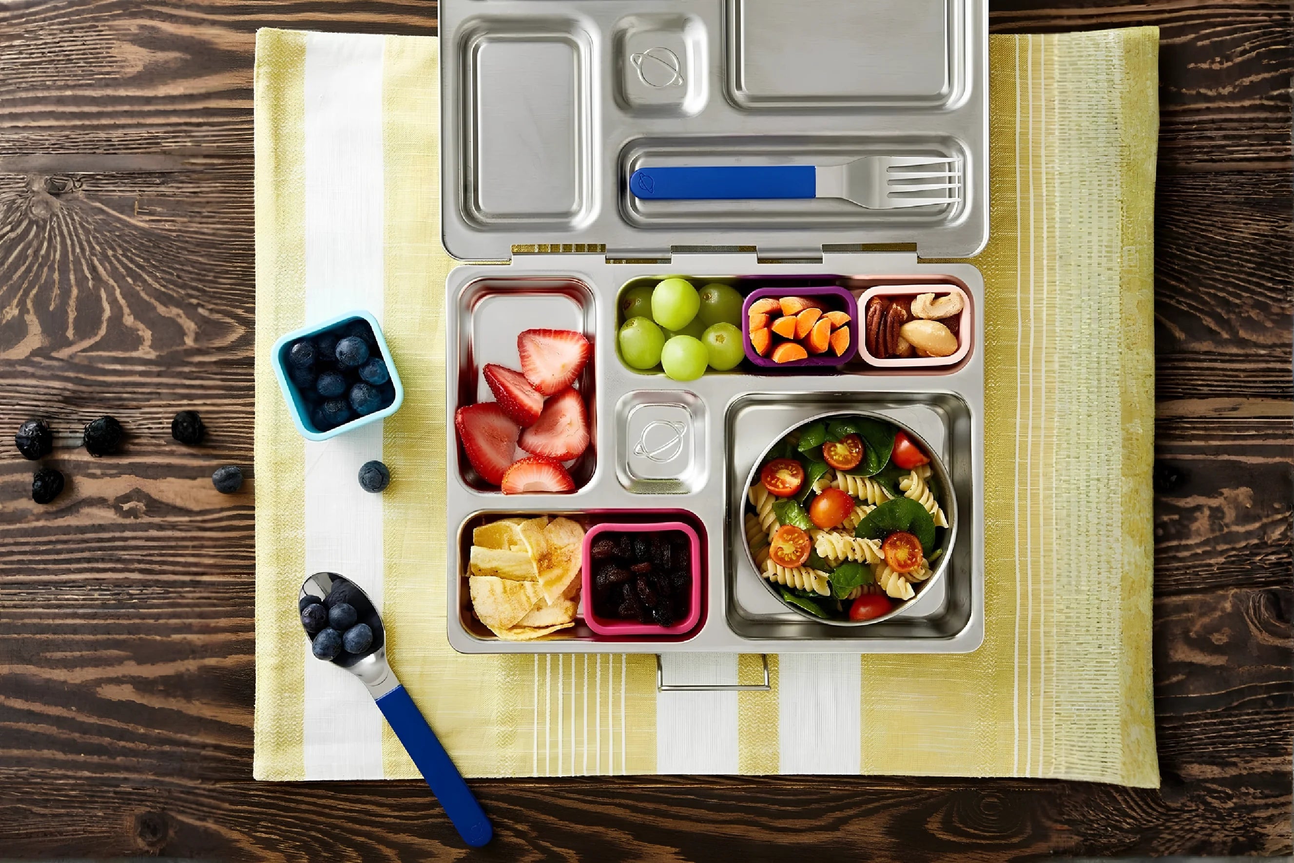 Balanced lunch box with fruits, vegetables, pasta and healthy snacks