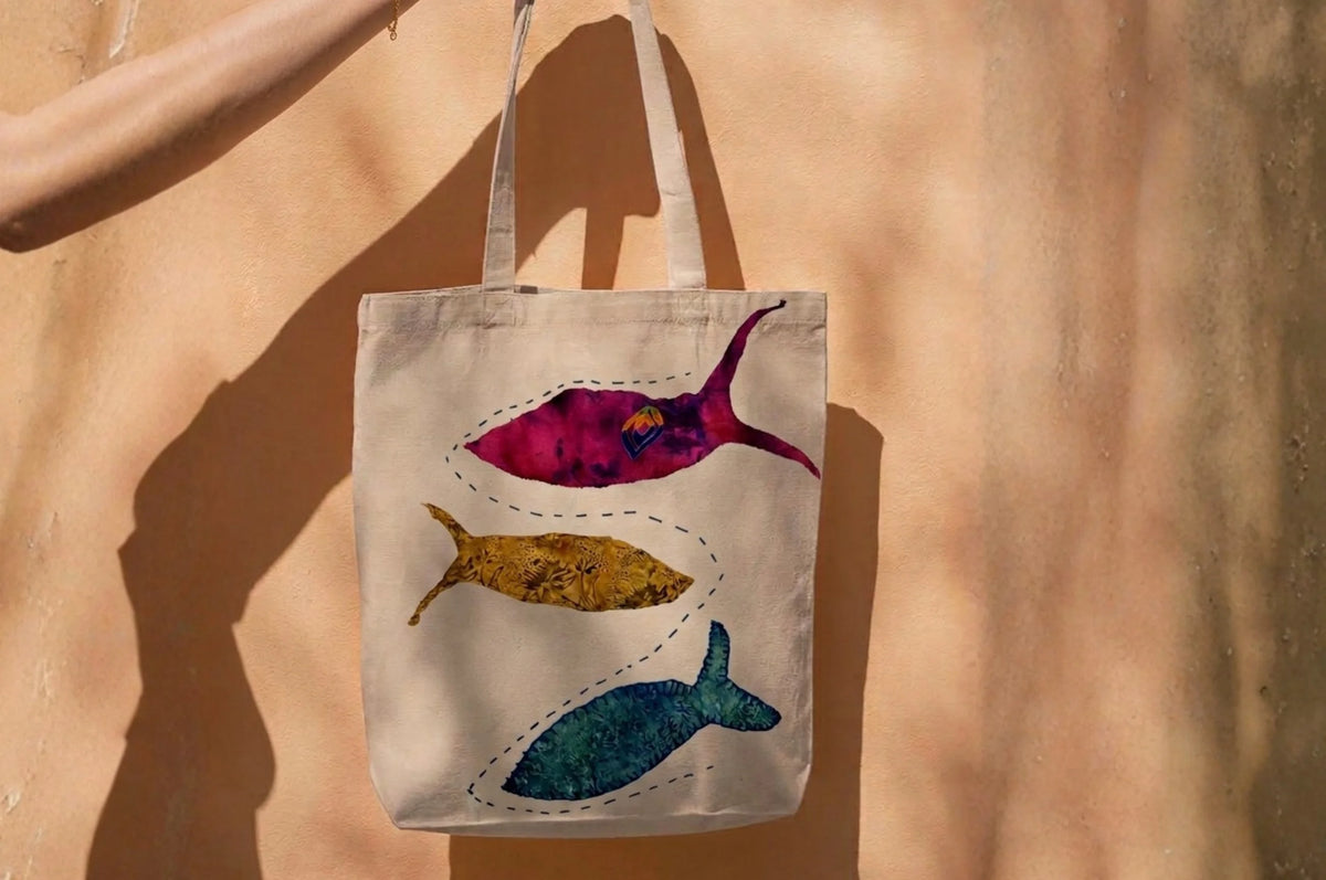 Canvas tote bag with three hand-appliquéd fish made from recycled fabric